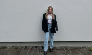 Elegancka stylizacja na koncert muzyki poważnej: biała koszula, czarna marynarka, jeansy i mokasyny.