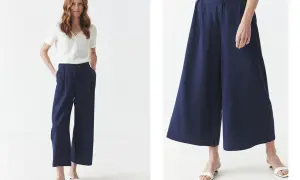 Kobieta w granatowych spodniach culotte i białej bluzce. Idealne dla każdej kobiety ceniącej wygodę i styl.