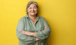 Uśmiechnięta kobieta w zielonej koszuli, uosobienie stylu i pewności siebie. Moda 60 plus w najlepszym wydaniu.
