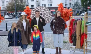 Rodzina prezentuje stylowe stylizacje na deszczowe dni. Dzieci w kolorowych kaloszach i kurtkach, dorośli w płaszczach i błyszczącej kurtce.
