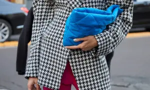 Elegancka marynarka w pepitkę, zestawiona z jaskrawymi różowymi spodniami i błękitną kopertówką, tworzy modne stylizacje.