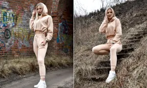 Eleganckie dresy stylizacje w beżowym kolorze. Kobieta w krótkiej bluzie z kapturem i dopasowanych spodniach prezentuje wygodny, ale stylowy look.