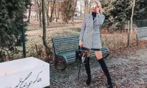 Elegancka sukienka w pepitkę, idealna na jesienne stylizacje. Kobieta w okularach przeciwsłonecznych i kozakach prezentuje modny zestaw.