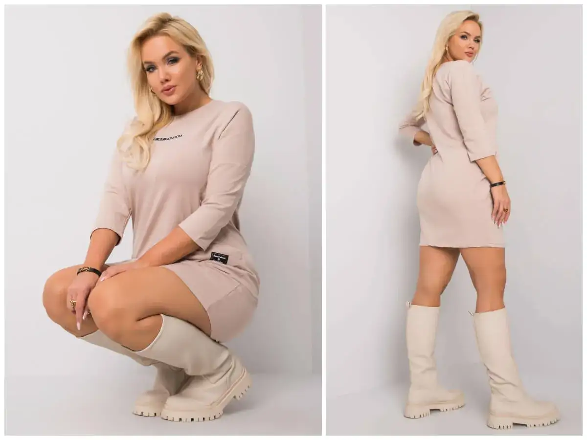 Eleganckie stylizacje plus size: modelka w beżowej sukience i kozakach.